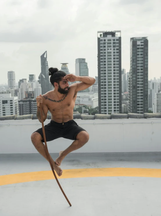 a man jumping in the air with a skateboard, by Jessie Alexandra Dick, arabesque, bangkok, holding a caduceus staff, standing on rooftop, martial artist dryad