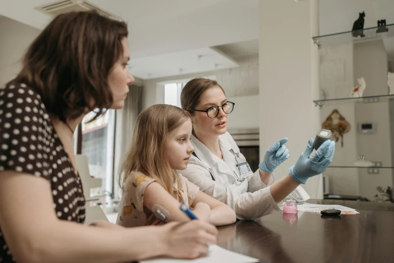 a woman and two young girls sitting at a table, pexels contest winner, analytical art, medical laboratory, 2806927615, resin, pharmacy