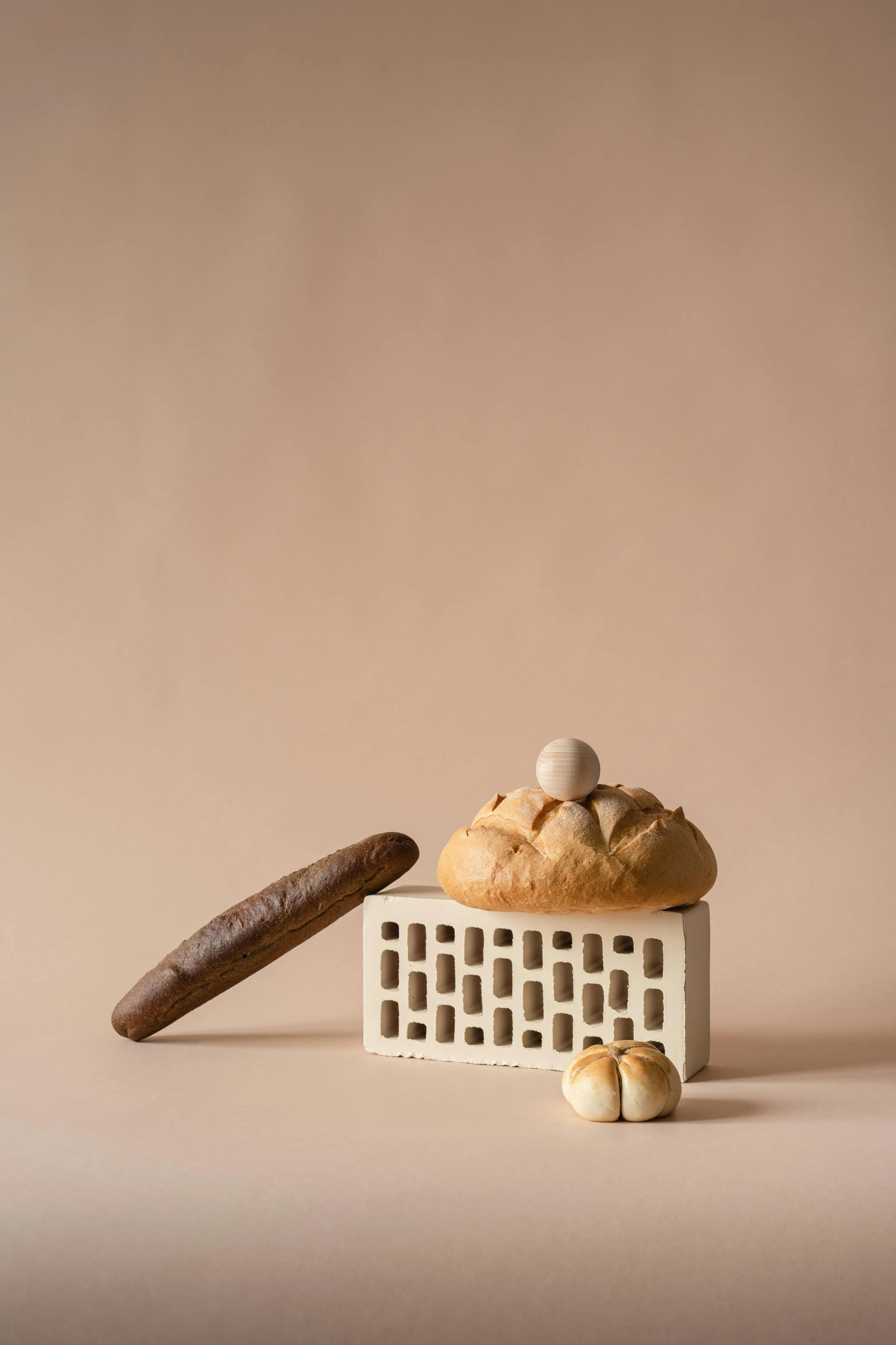 a cookie and a cigar sitting next to each other, a still life, inspired by Wilhelm Hammershøi, unsplash, romanesque, with bread in the slots, organic ceramic white, 9 0 mm studio photograph tiny, dough sculpture