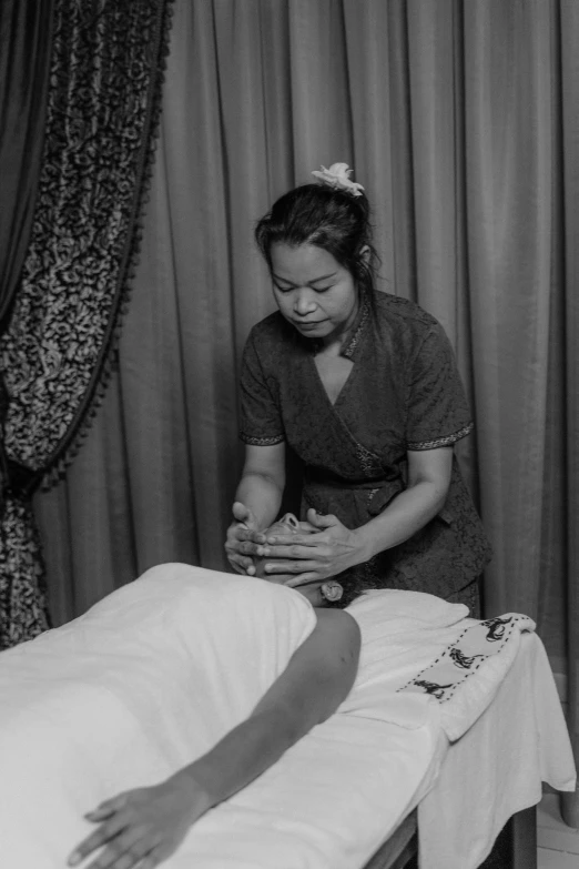 a black and white photo of a woman getting a massage, a black and white photo, by Ruth Jên, square, malaysian, gif, thai