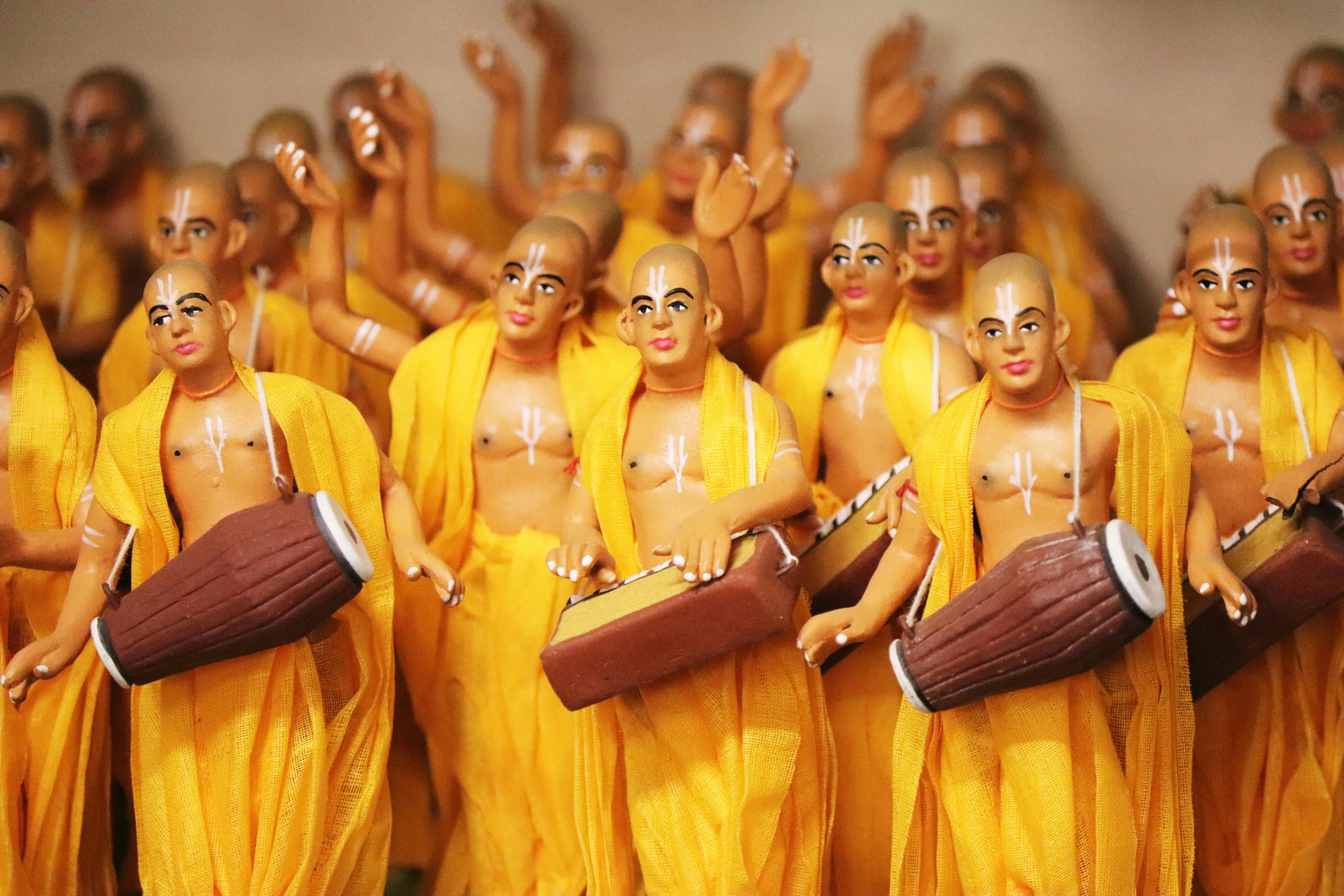 a group of men standing next to each other holding drums, a statue, flickr, samikshavad, yellow robes, pvc figurine, avatar image, sukhasana