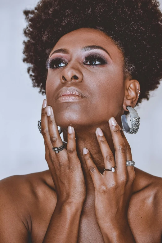 a woman with her hands on her face, trending on pexels, afrofuturism, square, 40 years old women, manicured, ebony rococo