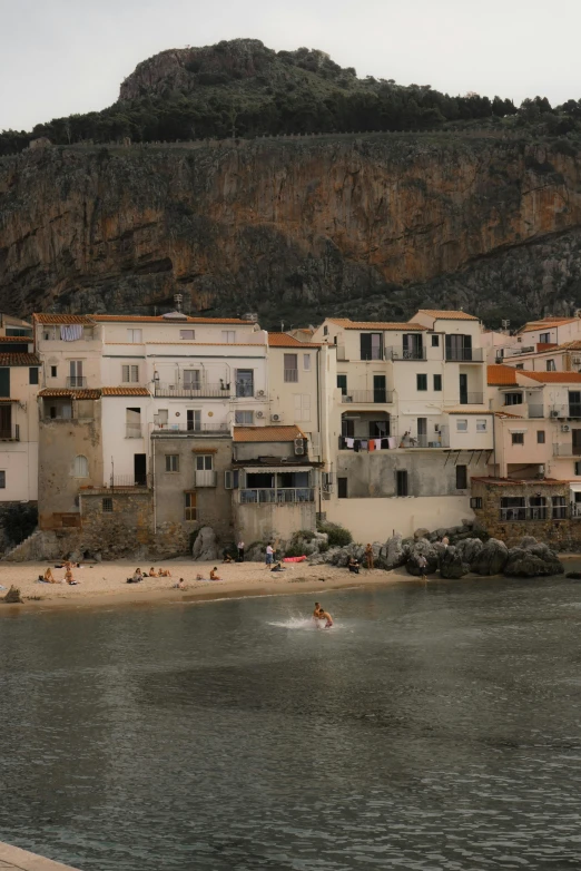 a group of people standing on top of a beach next to a body of water, renaissance, small port village, piroca, 8 k -, apartment