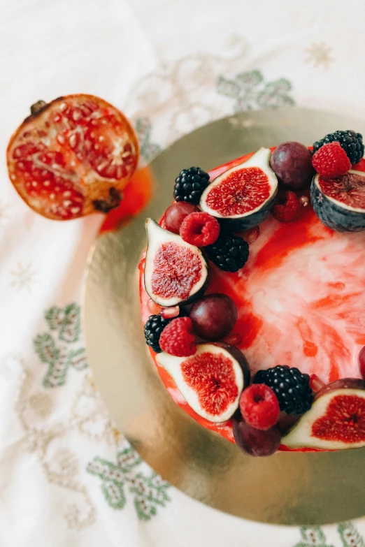 a cake sitting on top of a plate covered in fruit, red, decorations, flatlay, close-up photograph