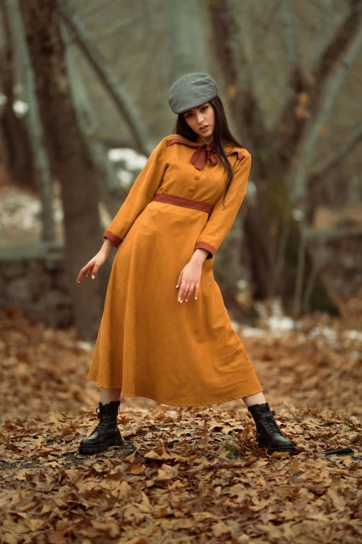 a woman in a yellow dress and a gray hat, inspired by Nikolai Ge, instagram, dark orange, in forest, official store photo, organic dress