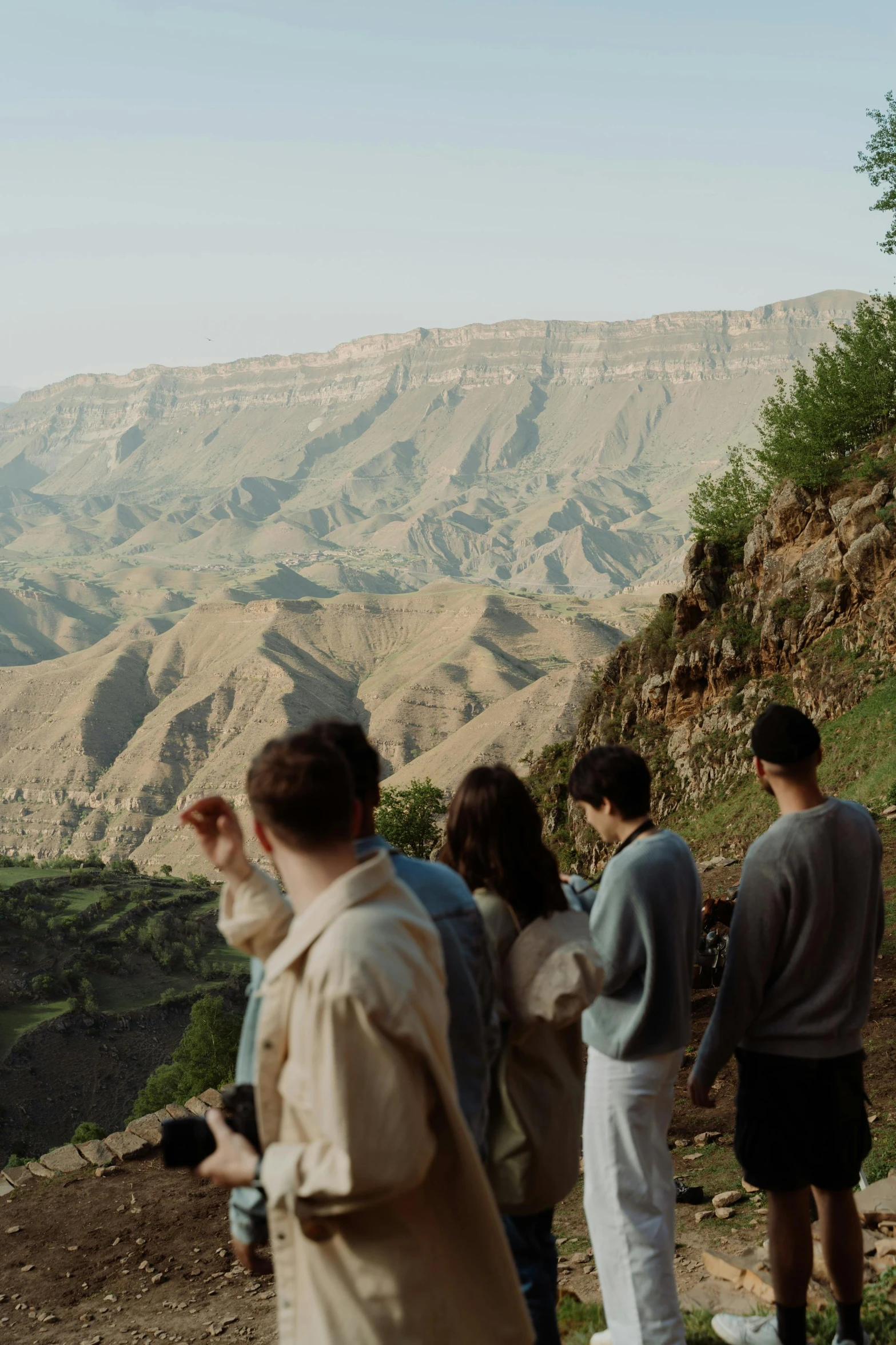 a group of people standing on top of a mountain, les nabis, cinematic silk road lanscape, in between a gorge, 8 k movie still, tehran