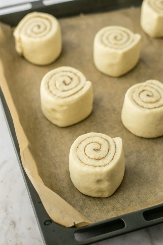 a pan filled with cinnamon rolls sitting on top of a counter, smooth contours, thumbnail, 6 pack, petite