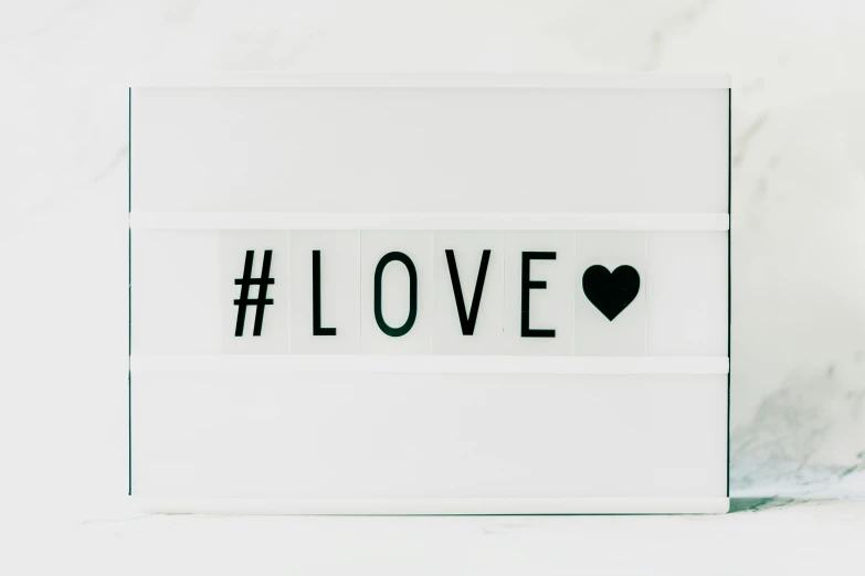 a white light box with the word love written on it, trending on pexels, white panels, hashtags, white and black color palette, 4 0 9 6