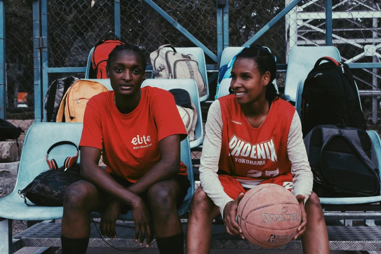 a couple of women sitting next to each other on a bench, featured on dribble, happening, wearing basketball jersey, ethiopian, elites, splento