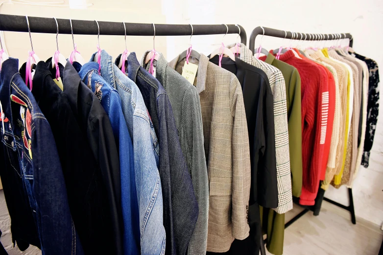 a bunch of clothes hanging on a rack, wearing jacket, archive pieces, sales, bright colour