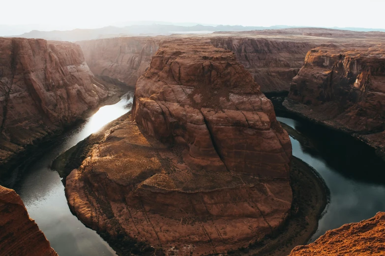 a river running through the middle of a canyon, pexels contest winner, sandstone, many smooth curves, faded glow, standing on a cliffside