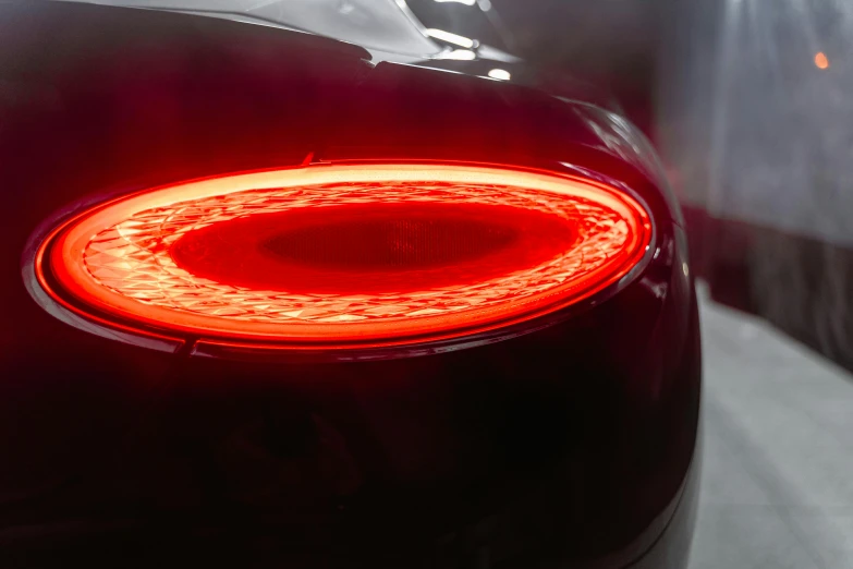 a close up of the tail lights of a car, a digital rendering, by David Donaldson, pexels contest winner, red oval turban, bentley, light tracing, photographed for reuters