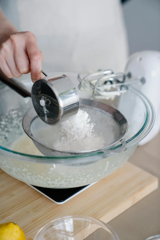 a person mixing ingredients in a bowl on a table, salt effects, detailed product image, kek, large tall