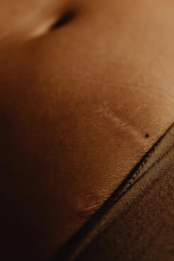 a close up of a brown leather couch, a macro photograph, by Alexander Mann, trending on pexels, tonal topstitching, paper grain, gold silk, thigh skin