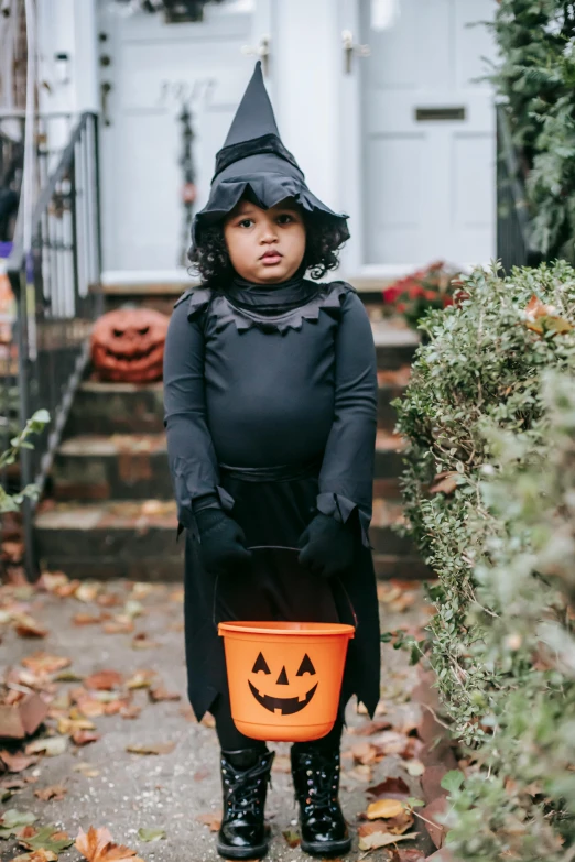 a little girl in a witch costume holding a bucket, pexels, cassandra cain, instagram picture, square, riyahd cassiem
