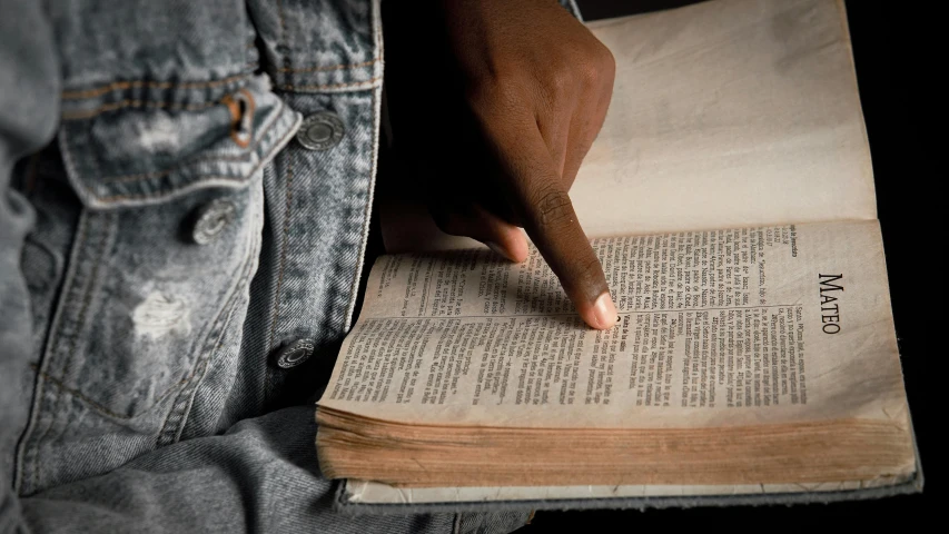 a close up of a person reading a book, biblical clothing, black man, thumbnail, distressed