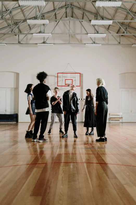 a group of people standing around a basketball court, by Nina Hamnett, dancers, in a school classroom, profile image, intimidating