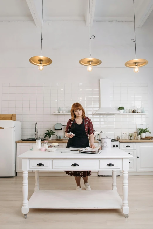 a woman sitting at a table in a kitchen, in a white boho style studio, woman with red hair, best chef, lya pilnev