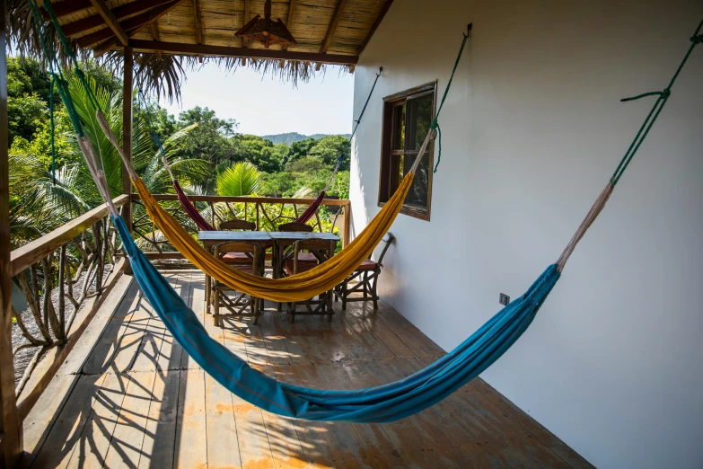 a hammock hanging from the side of a house, inspired by Ceferí Olivé, unsplash, panoramic view, fan favorite, ecovillage, full room view