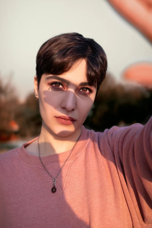 a woman making a stop sign with her hand, an album cover, inspired by Elsa Bleda, trending on pexels, photorealism, androgynous face, beautiful iranian woman, ((sunset)), twitch streamer