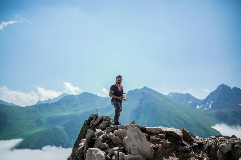 a man standing on top of a rocky mountain, ash thorp khyzyl saleem, background image, georgic, multiple stories
