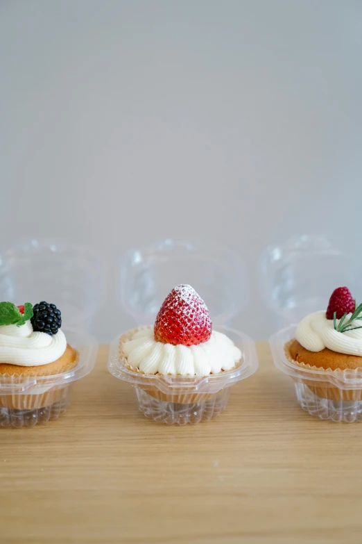 a row of cupcakes sitting on top of a wooden table