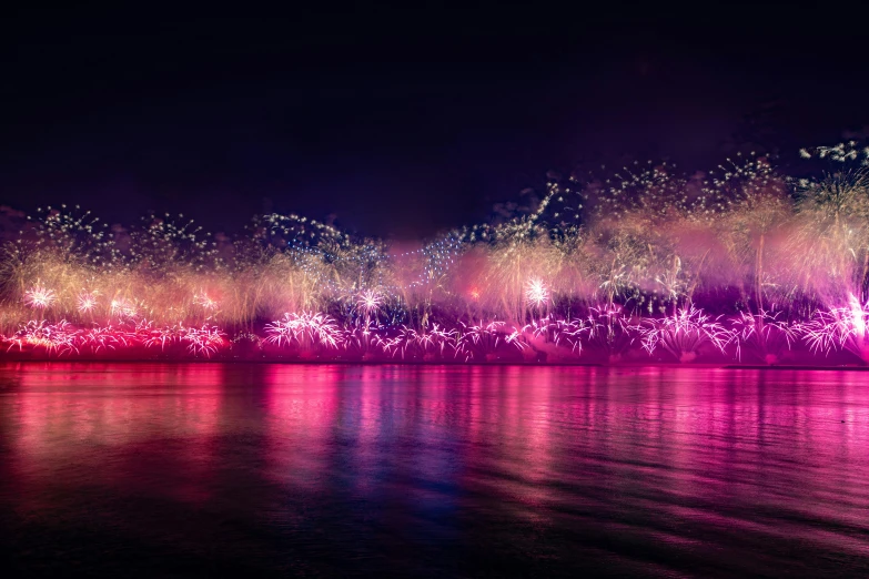 fireworks light up the night sky over a body of water, by Matteo Pérez, pexels contest winner, pink and purple, rio de janeiro, colorized background, numerous fires