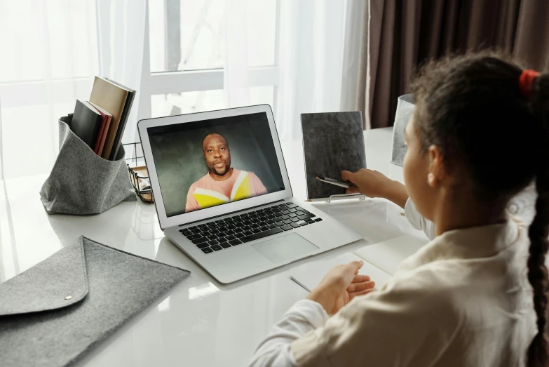 a little girl sitting in front of a laptop computer, a portrait, by Julia Pishtar, pexels contest winner, video art, in meeting together, photo of a black woman, a photo of a man, long distance shot