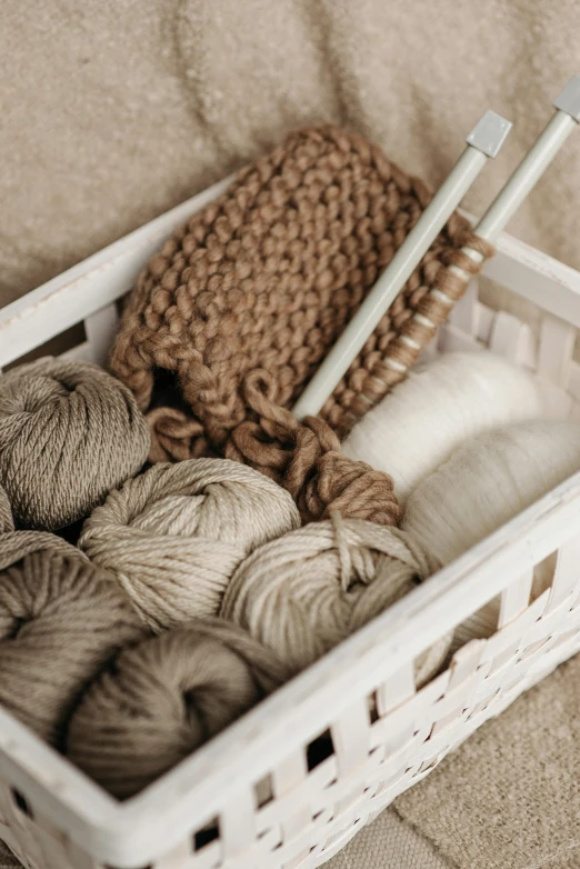 a basket filled with yarn and knitting needles, inspired by Eden Box, unsplash, brown and white color scheme, toys, beige, white