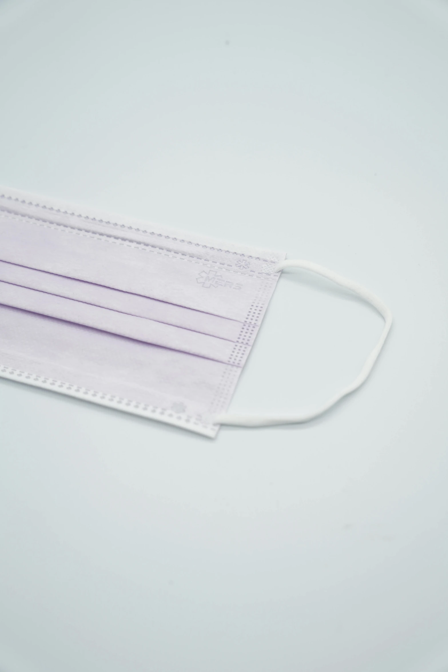 a purple face mask sitting on top of a white table, medical supplies, high detail product photo, rectangular face, 1 0 / 1 0