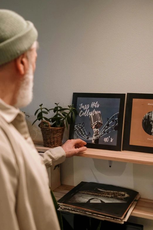 a man that is standing in front of a shelf, poster art, pexels contest winner, art & language, detailed photo of an album cover, square pictureframes, old man, music being played