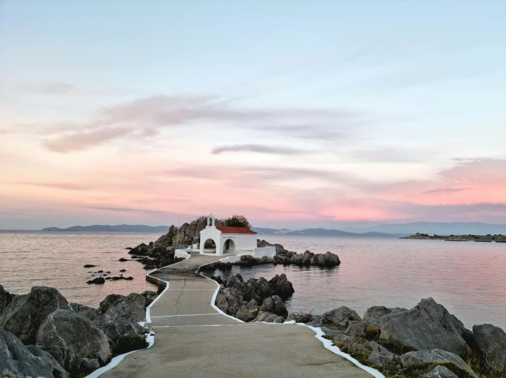 a walkway that is next to a body of water, a picture, greece, pink skies, profile image, grotto