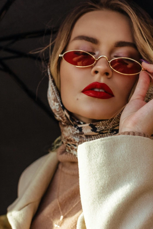 a woman wearing sunglasses and a scarf holding an umbrella, inspired by Hedi Xandt, trending on pexels, wearing turtleneck, gold and red, lips, muslim