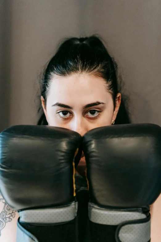 a close up of a person wearing boxing gloves, women's faces, baggy eyes, strength, black horns