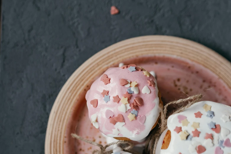 a pink plate topped with donuts covered in sprinkles, a colorized photo, by Emma Andijewska, trending on pexels, whipped cream, on a gray background, hearts, background image