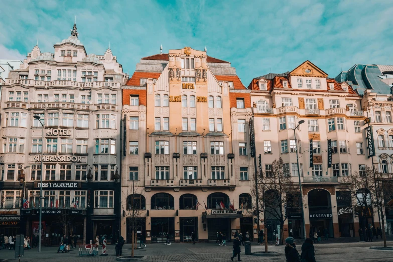 a group of buildings on a city street, a photo, by Emma Andijewska, pexels contest winner, art nouveau, square, thumbnail, high quality upload, jugendstil