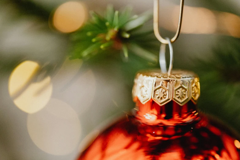 a red ornament hanging from a christmas tree, pexels contest winner, arts and crafts movement, glossy surface, warm coloured, thumbnail, miniature photography closeup