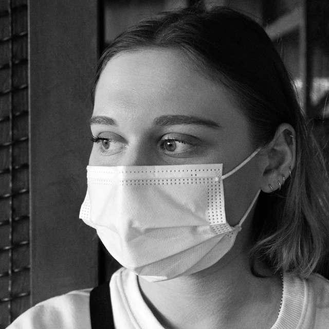 a black and white photo of a woman wearing a face mask, by Emma Andijewska, pexels, nurse, 🤤 girl portrait, girl with white eyes, student