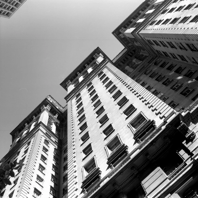 a black and white photo of tall buildings, by Mike Bierek, neo - classical style, worm's - eye view, san francisco, building crumbling