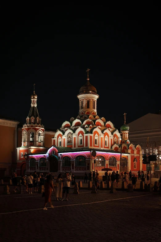 a group of people standing in front of a building, inspired by Vasily Surikov, pexels contest winner, renaissance, reddish exterior lighting, square, orthodox icons, (night)