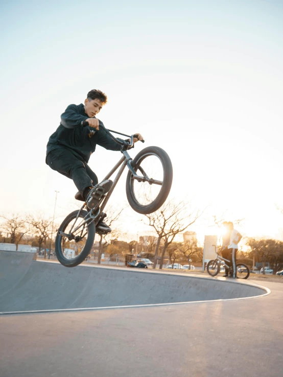 a man flying through the air while riding a bike, inspired by Seb McKinnon, pexels contest winner, realism, at a skate park, sun down, pete davidson, kailee mandel