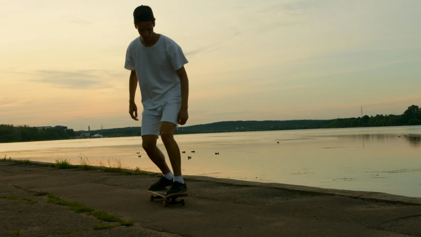 a man riding a skateboard down a sidewalk next to a body of water, a picture, summer evening, nathan fowkes, shoreline, blank