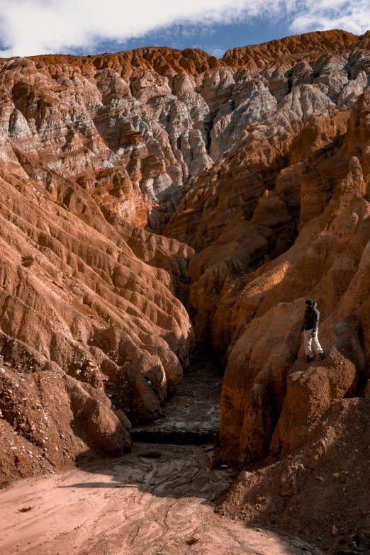 a man riding a motorcycle down a dirt road, an album cover, inspired by Steve McCurry, unsplash contest winner, chiseled formations, found in a cave made of clay, nasa true color 8k image, chocolate river