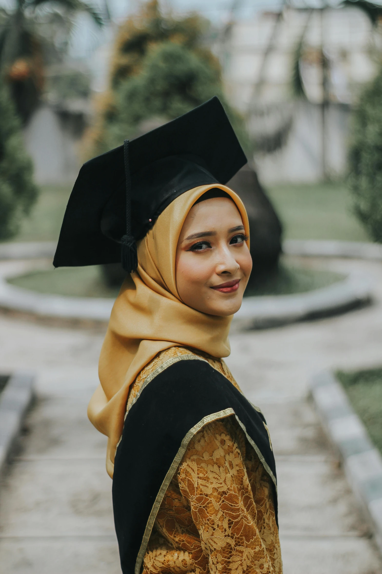 a woman wearing a graduation cap and gown, by Basuki Abdullah, square, gold, high quality upload, wide forehead