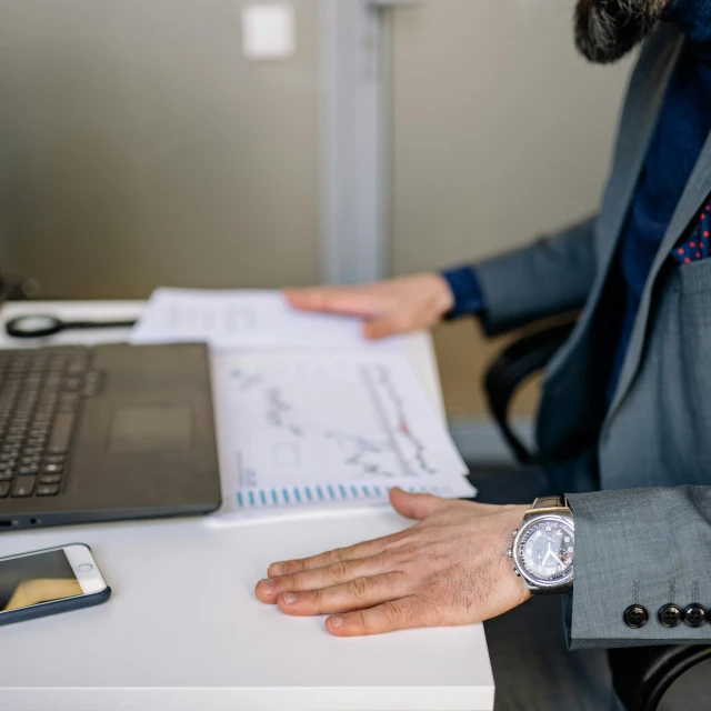 a man sitting at a desk in front of a laptop computer, by Carey Morris, pexels, wearing business casual dress, hand holdings, scientific document, 2019 trending photo