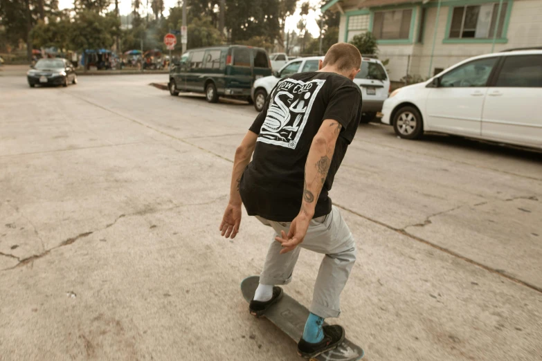 a man riding a skateboard down a street, a picture, graphic tees, structure : kyle lambert, half turned around, full product shot