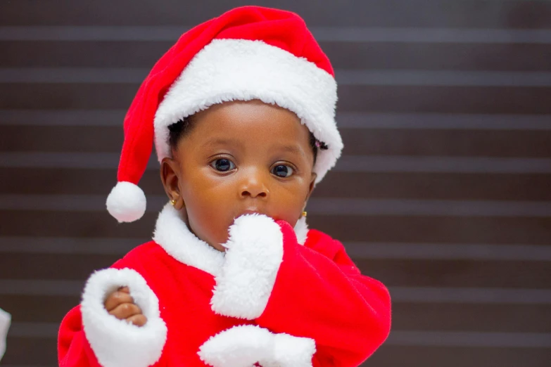 a close up of a child wearing a santa suit, by Chinwe Chukwuogo-Roy, pexels, 15081959 21121991 01012000 4k, thumbnail, hi - res, instagram post