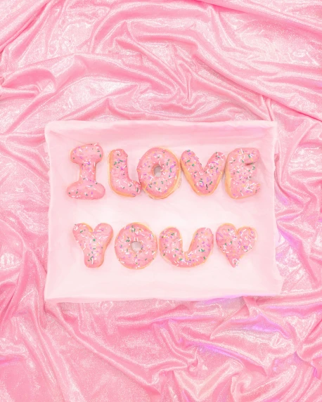 a white plate topped with donuts covered in sprinkles, an album cover, by Julia Pishtar, i love you, pastel pink neon, embroidered velvet, close-up photograph