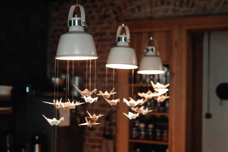 a bunch of origami hanging from a ceiling, inspired by Miyagawa Chōshun, trending on pexels, kinetic art, gas lamps, holding electricity and birds, porcelain organic, with photorealistic lighting