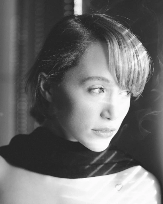 a black and white photo of a woman looking out a window, inspired by Zoë Mozert, with a bob cut, emilia clarke, square, ansel ]